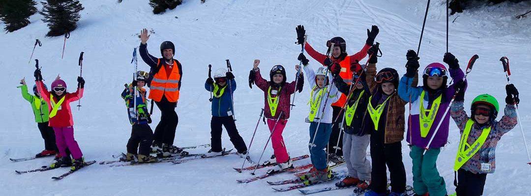 Enfants et leurs moniteurs sur une piste de ski